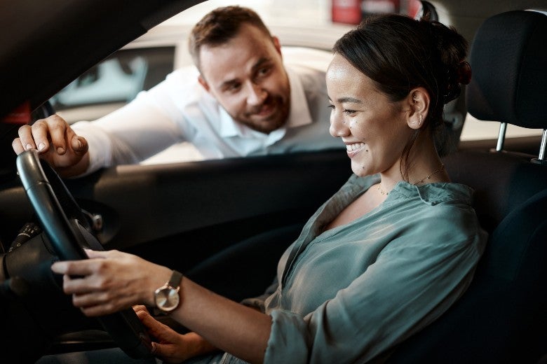 Salesman showing woman care for test drive