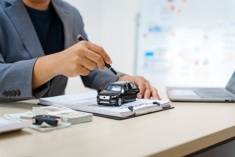 Salesman pointing at toy car